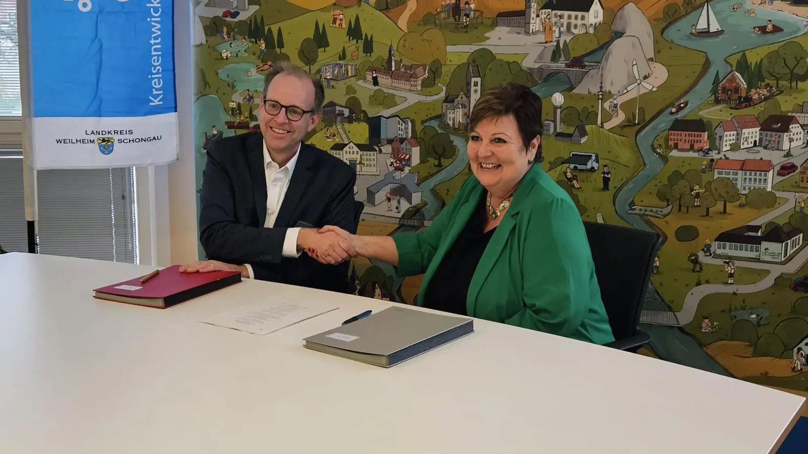 Hand drauf“ – MVV-Geschäftsführer Dr. Bernd Rosenbusch und Landrätin Andrea Jochner-Weiß unterzeichnen die MVV-Verbundpartner-Verträge. (Foto: Landratsamt)