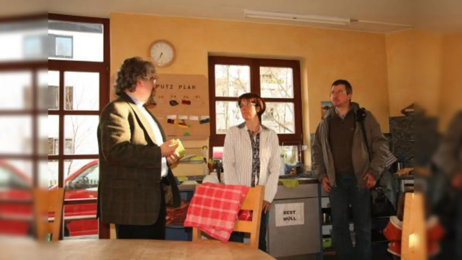 Mit Putz- und Kochplan werden die Jugendlichen in der Wohngemeinschaft Neufeldstraße zur Selbstständigkeit angehalten. Bei einem Besuch des BA erklärten der Leiter Michael Alberts und Vorstandsmitglied Marion Saumweber (v.l.) das pädagogische Konzept. Rechts BA-Vorsitzender Christian Müller. (Foto: US)