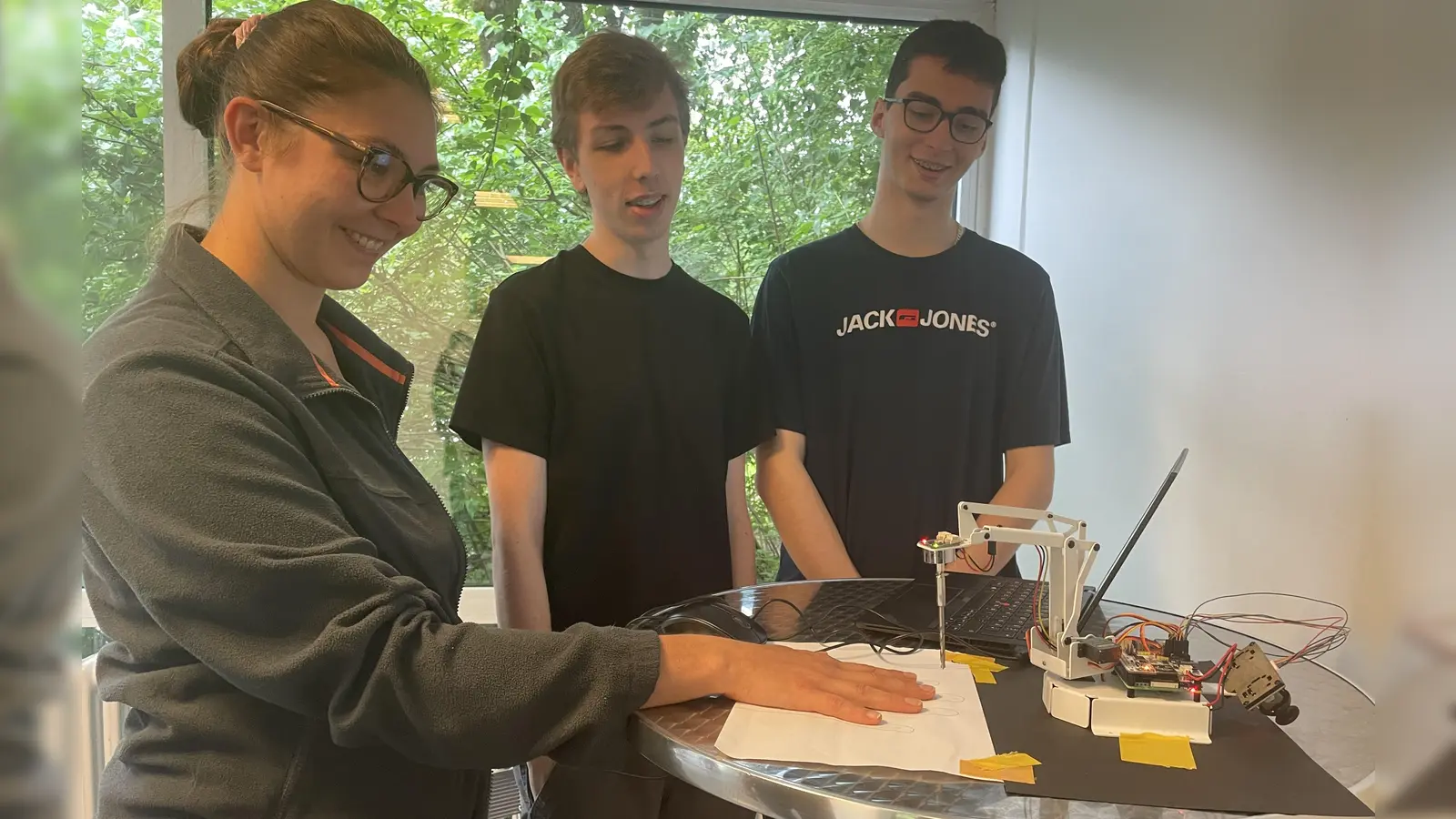 Experiment geglückt - alle Finger sind unverletzt geblieben, Marco (Mitte) und Stefan haben den Roboterarm für einen Nervenkitzel programmiert.  (Foto: pst)