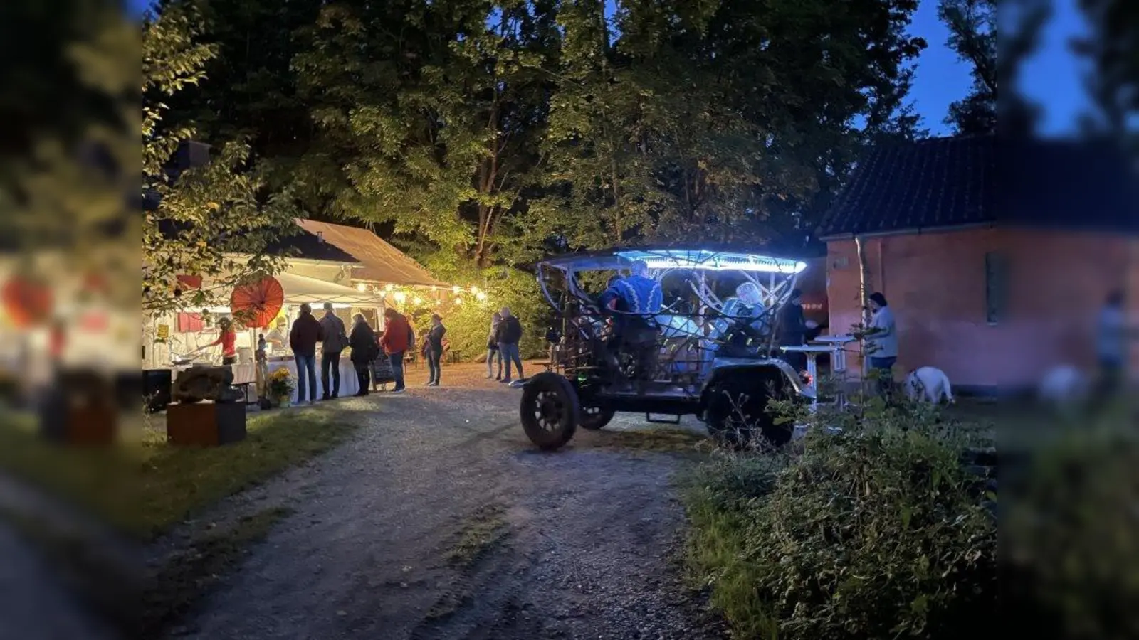 Am Abend war das Gelände in ein zauberhaftes Licht gehüllt. Rechts ist die blau beleuchtete „Mistkutschn” von Stefan Reitsam. (Foto: pst)