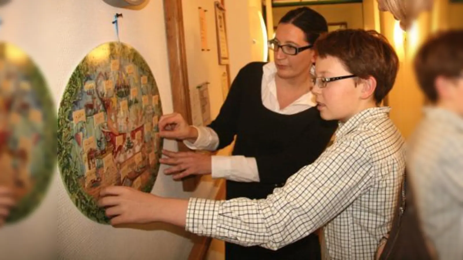 Das Altenheim Planegg stellt eine große Sammlung von historischen und modernern Adventskalendern aus. „Wir freuen uns auf viele Besucher. Jung und Alt sind gerne gesehen“, so Heimleiter Ulrich Spies. Im Bild Karola Albrecht mit Sohn Felix. (Foto: US)