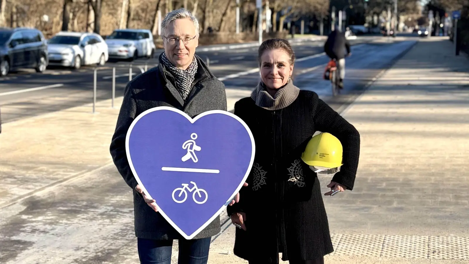 Baureferentin Dr.-Ing. Jeanne-Marie Ehbauer und Mobilitätsreferent Georg Dunkel zeigen Herz bei der Eröffnung des 1. Bauabschnitts der Karl-Theodor-Straße: Die Stadt geht mit der fußgänger- und radfahrerfreundlichen Umgestaltung wieder einen Schritt in Richtung „Vision Zero”. (F.: Baureferat )