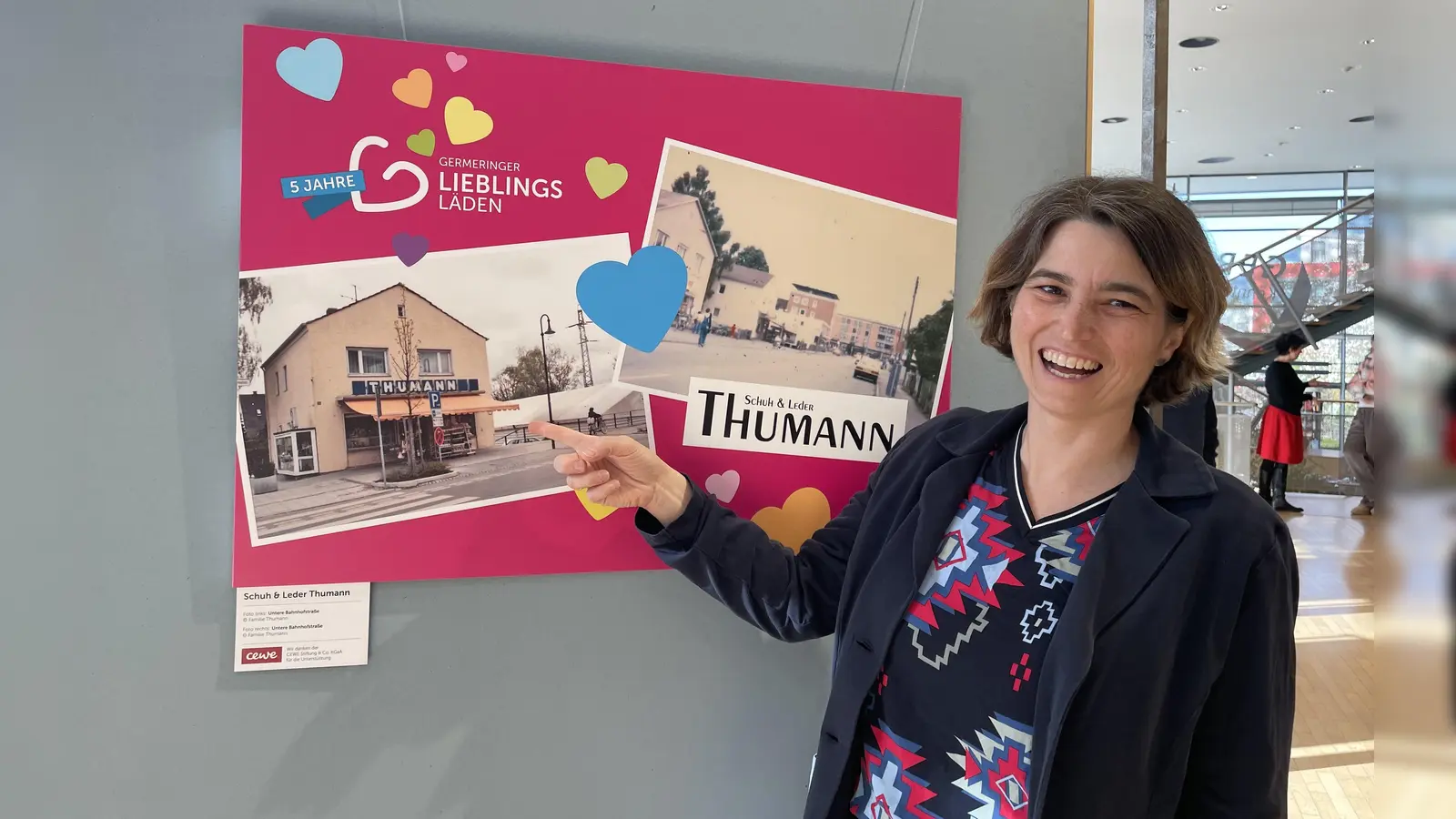 Verena Thumann zeigt auf die alten Fotos aus dem Familienalbum, die das alte Geschäftshaus in der Unteren Bahnhofstraße zeigen. (Foto: pst)