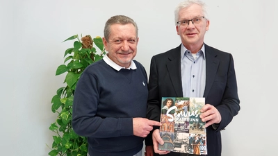 Grasbrunns Erster Bürgermeister Klaus Korneder (links) und Rolf Katzendobler, Ortschronist der Gemeinde Grasbrunn und Kreisdenkmalpfleger im Landkreis München, mit dem neu erschienenen Buch „Servus Grasbrunn. Eine Zeitreise durch die Jahrhunderte“. (Foto: Gemeinde Grasbrunn)