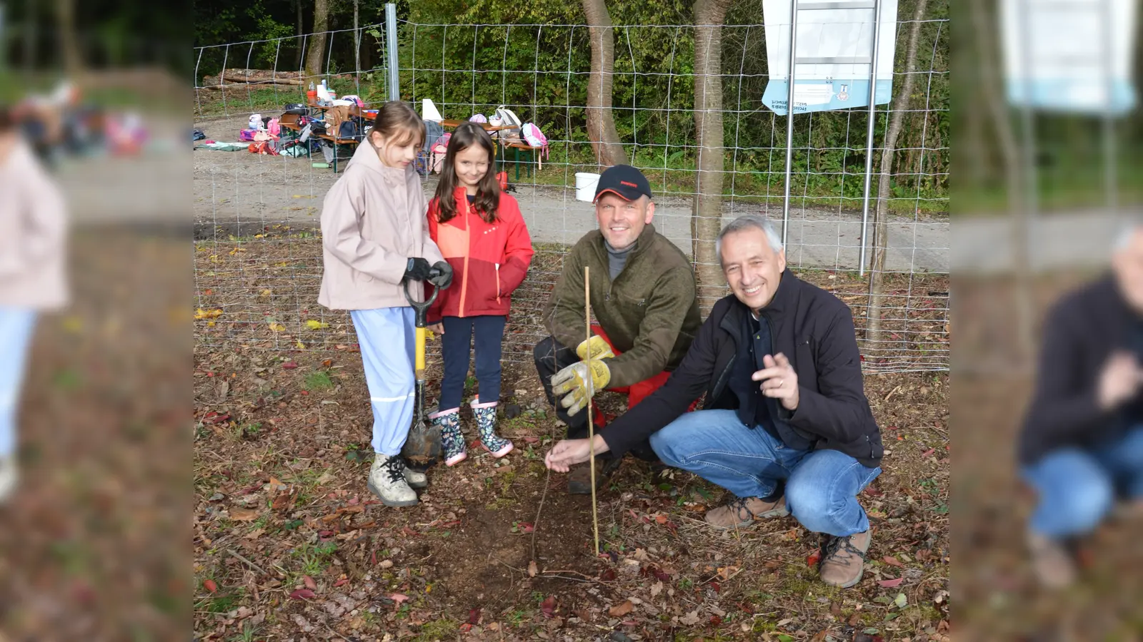 Puchheims Bürgermeister Norbert Seidl (re.) und Forstwirt Ricardo Steinig mit Kindern an einer neu gepflanzten Wildbirne  (Foto: M. Koch/AELF)