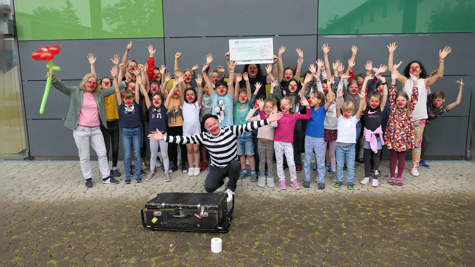 Freuen sich über die erlaufene Spende: Kinder der Grundschule Feldkirchen, Schulleiterin Sabine Kremser (1. von links), Lehrerin Cornelia Keller, die Organisatorin des Spendenlaufs (1. von rechts) sowie Vertreter von Lions Club Aschheim und dem Elternbeirat. (Foto: Lions Club Aschheim)