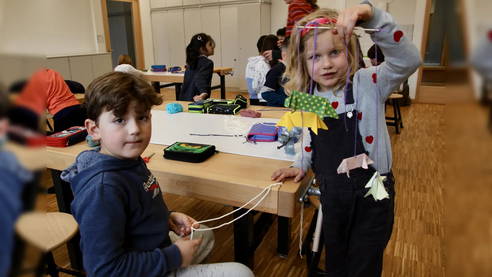 Mobiles fürs eigene Kinderzimmer: die Erstklässler zeigen stolz ihre fertigen Werke, die in der Tüftel AG entstanden sind.  (Foto: us)