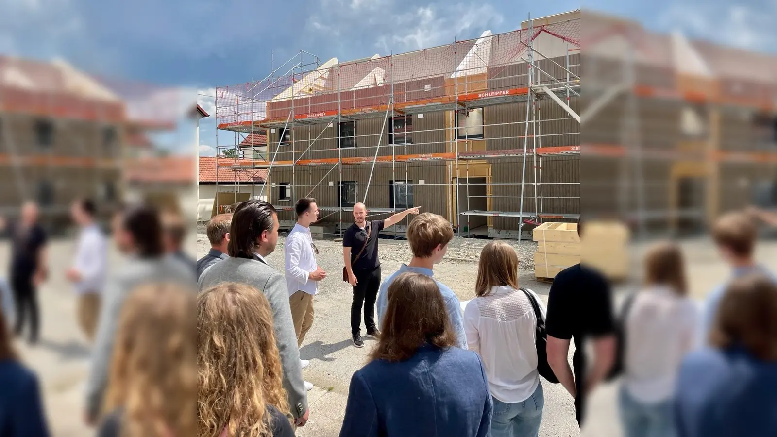 Wohnbau-Geschäftsführer Florian Steinbach (Mitte) erklärte dem JU-Vorsitzenden Julius Ferg (links) und Besucherinnen und Besuchern die Entwicklung der Bauarbeiten am Barbarahof. (Foto: JU Weilheim-Schongau)