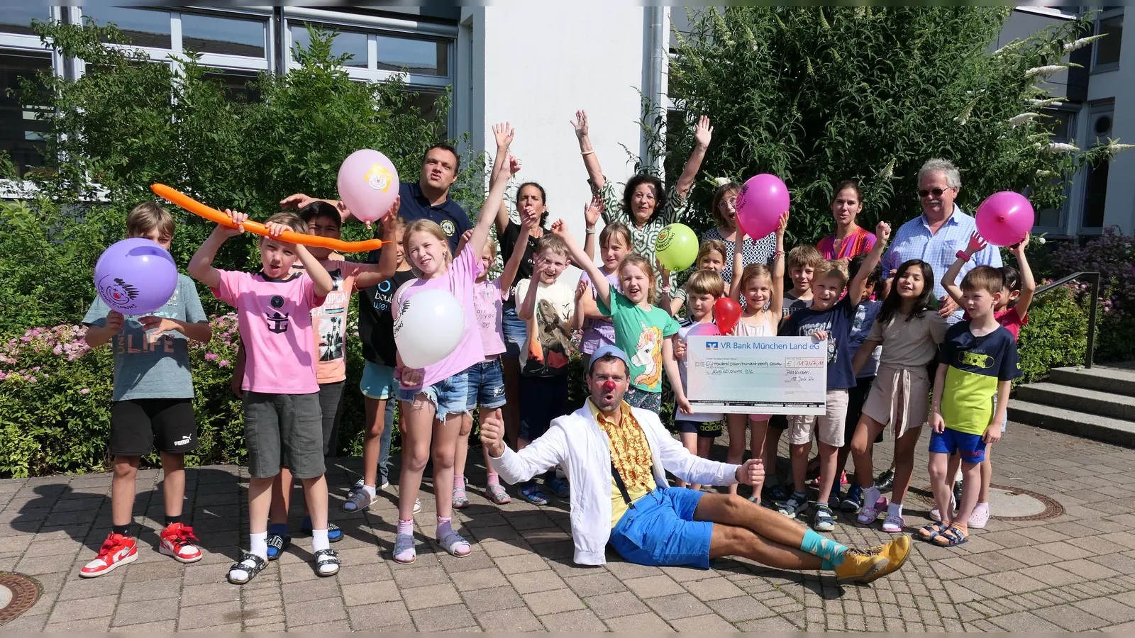 Clown Dr. Batscho (vorne) freute sich über das große Engagement der Schülerinnen und Schüler - und über einen Scheck über 11.700 Euro. (Foto: Lionsclub Aschheim)
