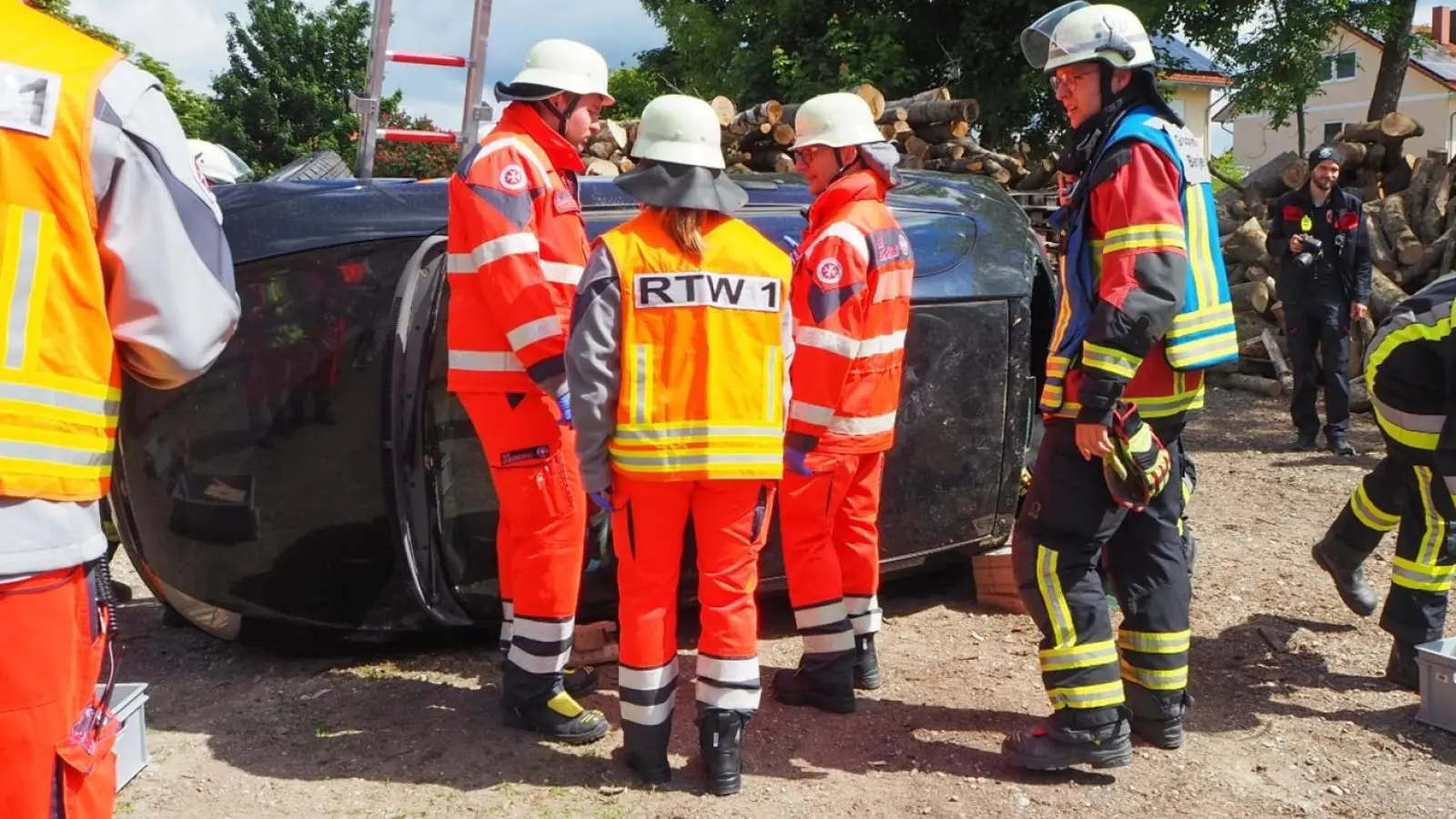 Die Einsatzkräfte der Johanniter, darunter Barbara Paintner (FSJ, Rettungssanitäterin, Aufschrift „RTW 1”), und die Feuerwehr Berglern bei einer Übung mit einem umgekippten PKW.<br> (Foto: Johanniter)